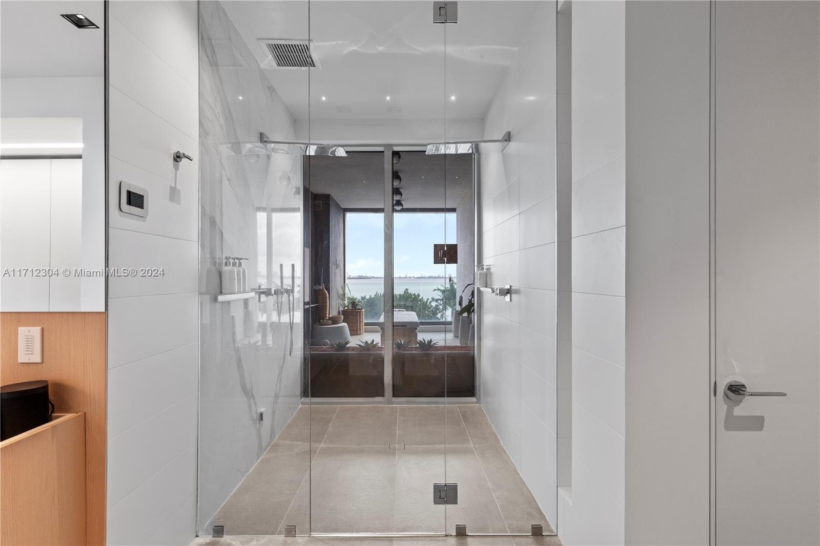 650 Northeast 32nd Street, Unit BH2 Miami, FL 33137 - Photo 14 of 30 a bathroom with a glass door shower