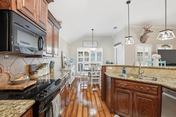 a kitchen with stainless steel appliances granite countertop a stove and a sink