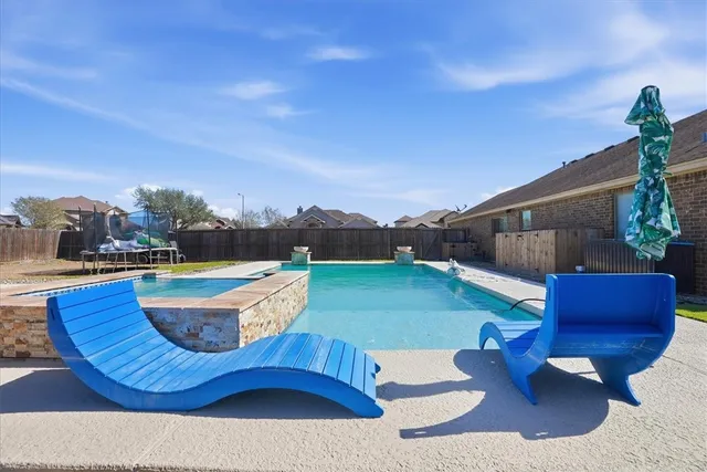 a swimming pool with outdoor seating and barbeque