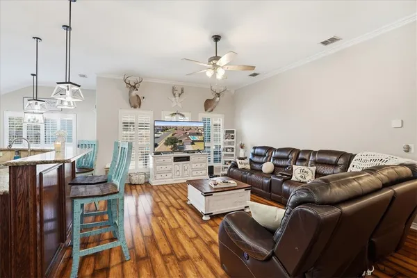 a living room with furniture kitchen view and a chandelier