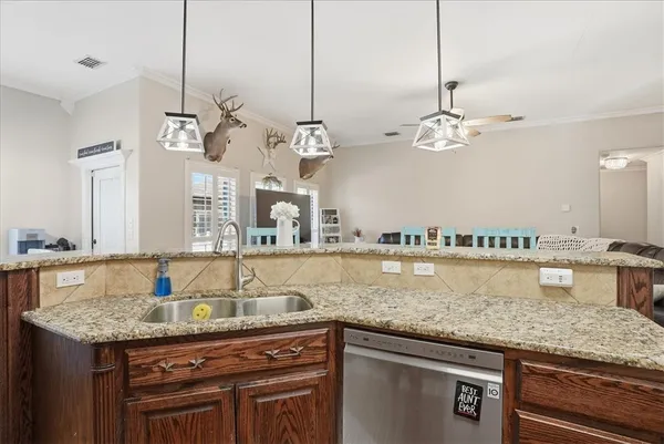 a kitchen with kitchen island granite countertop a sink and chandelier