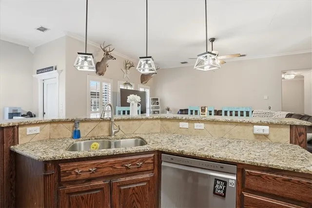 a kitchen with kitchen island granite countertop a sink and chandelier