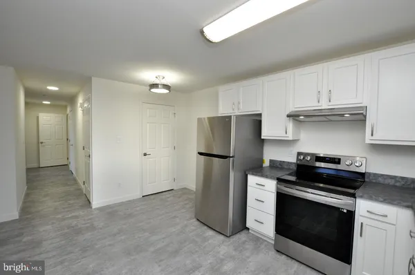 a kitchen with a stove a refrigerator and a sink