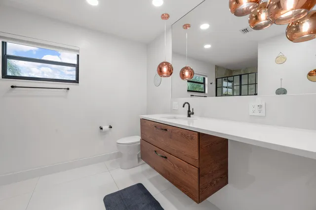 a bathroom with a sink a toilet and a mirror