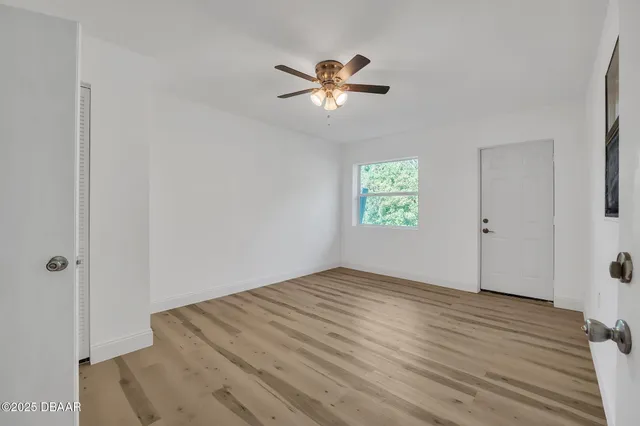 a view of empty room with wooden floor