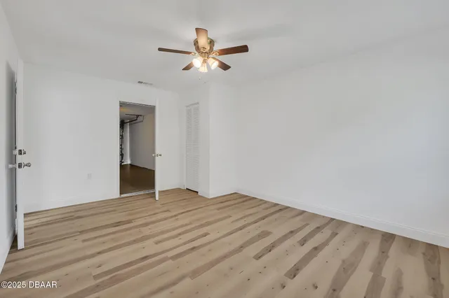 a view of empty room with wooden floor