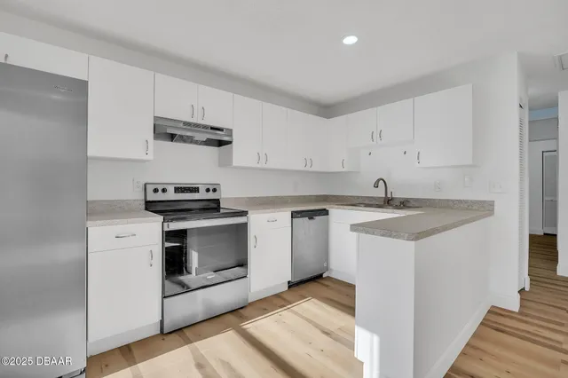 a kitchen with stainless steel appliances white cabinets and a sink