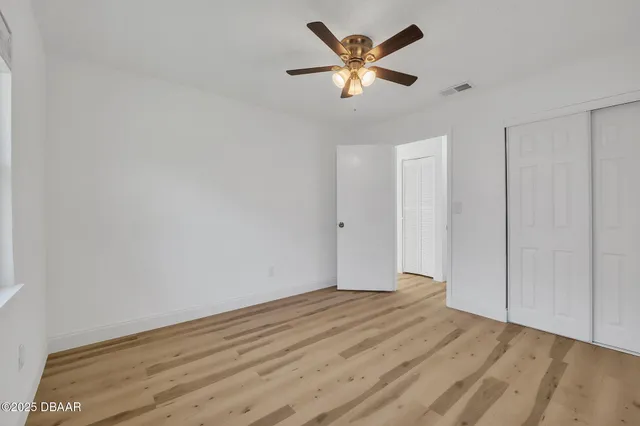 a view of a big room with wooden floor and a ceiling fan