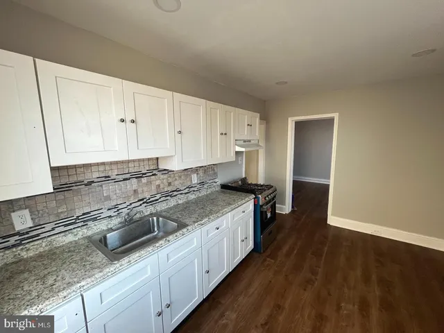 a kitchen with stainless steel appliances granite countertop a sink stove and cabinets