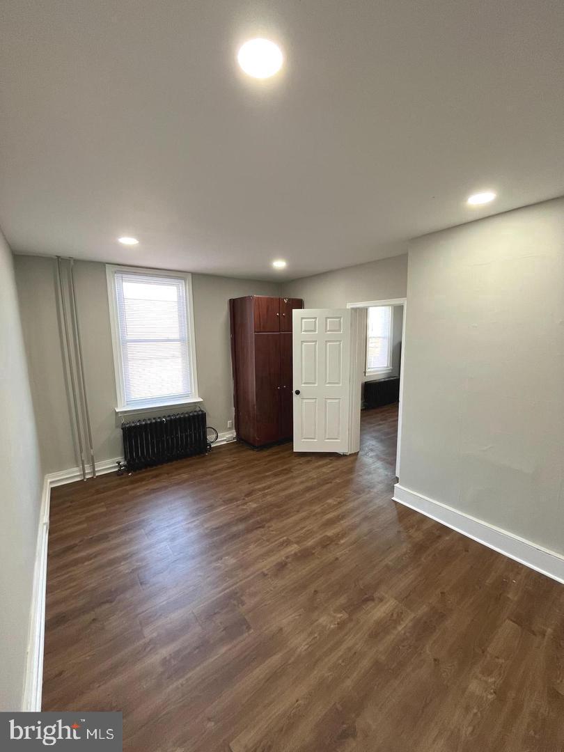 1251 East Fletcher Street, Unit 2R Philadelphia, PA 19125 - Photo 4 of 6 an empty room with wooden floor and windows