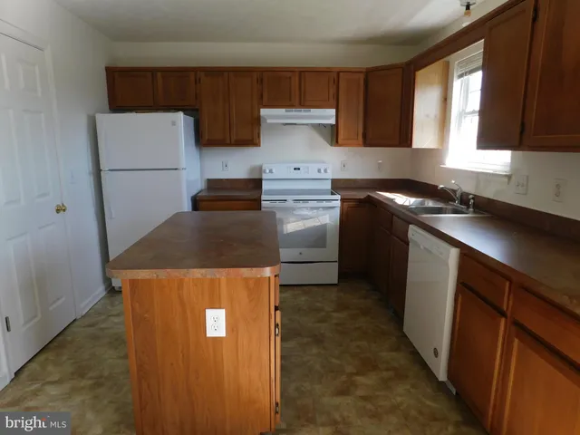 a kitchen with a refrigerator a stove a sink and a window