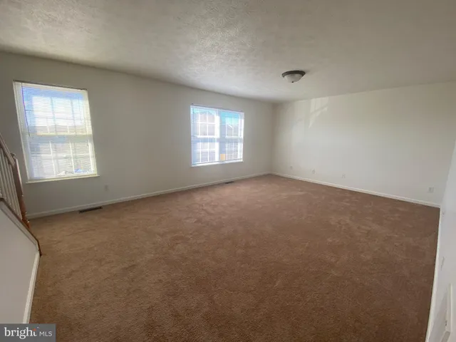 an empty room with a windows and closet