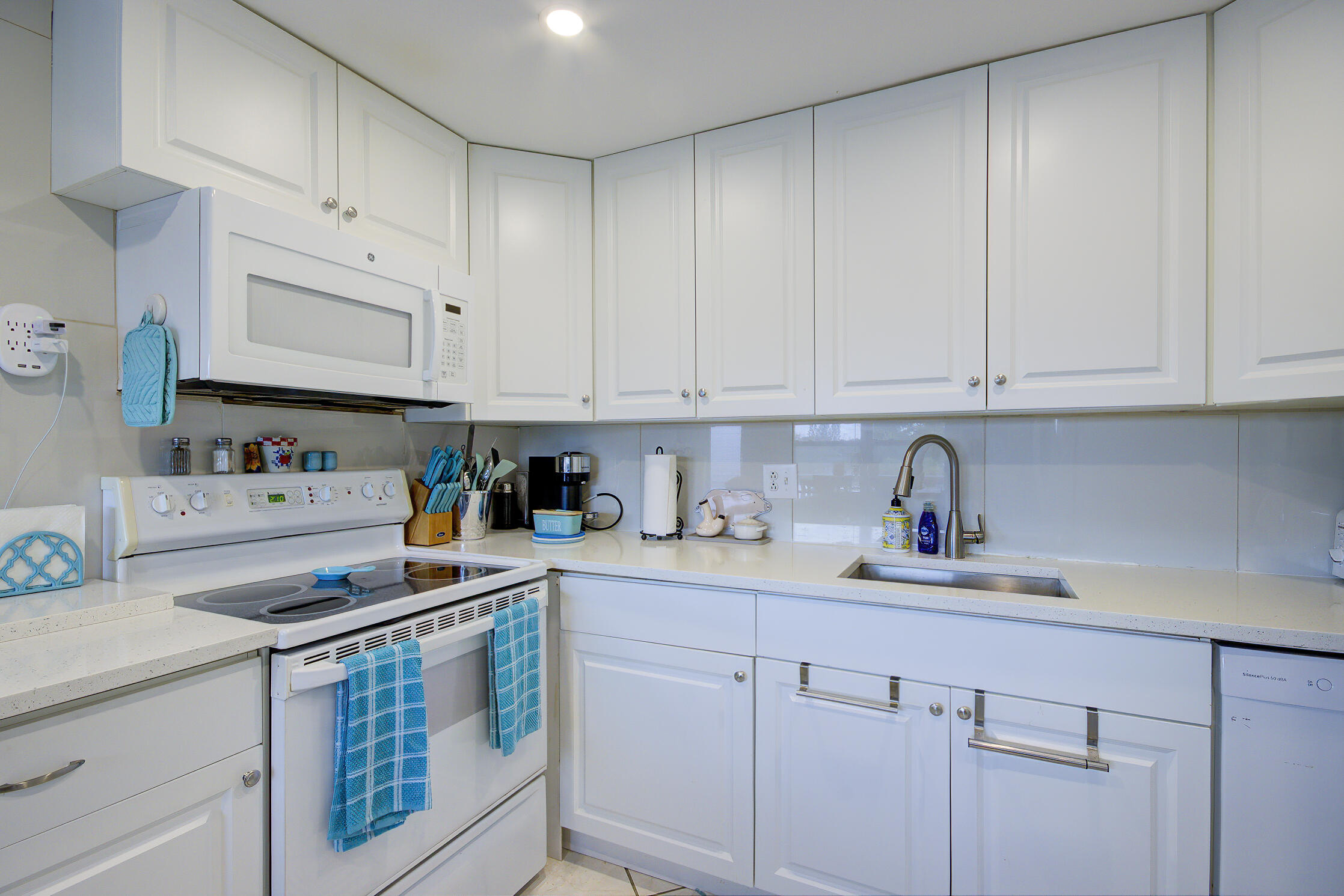 363 Wellington J West Palm Beach, FL 33417 - Photo 6 of 17 a kitchen with stainless steel appliances granite countertop a sink dishwasher stove and cabinets with wooden floor