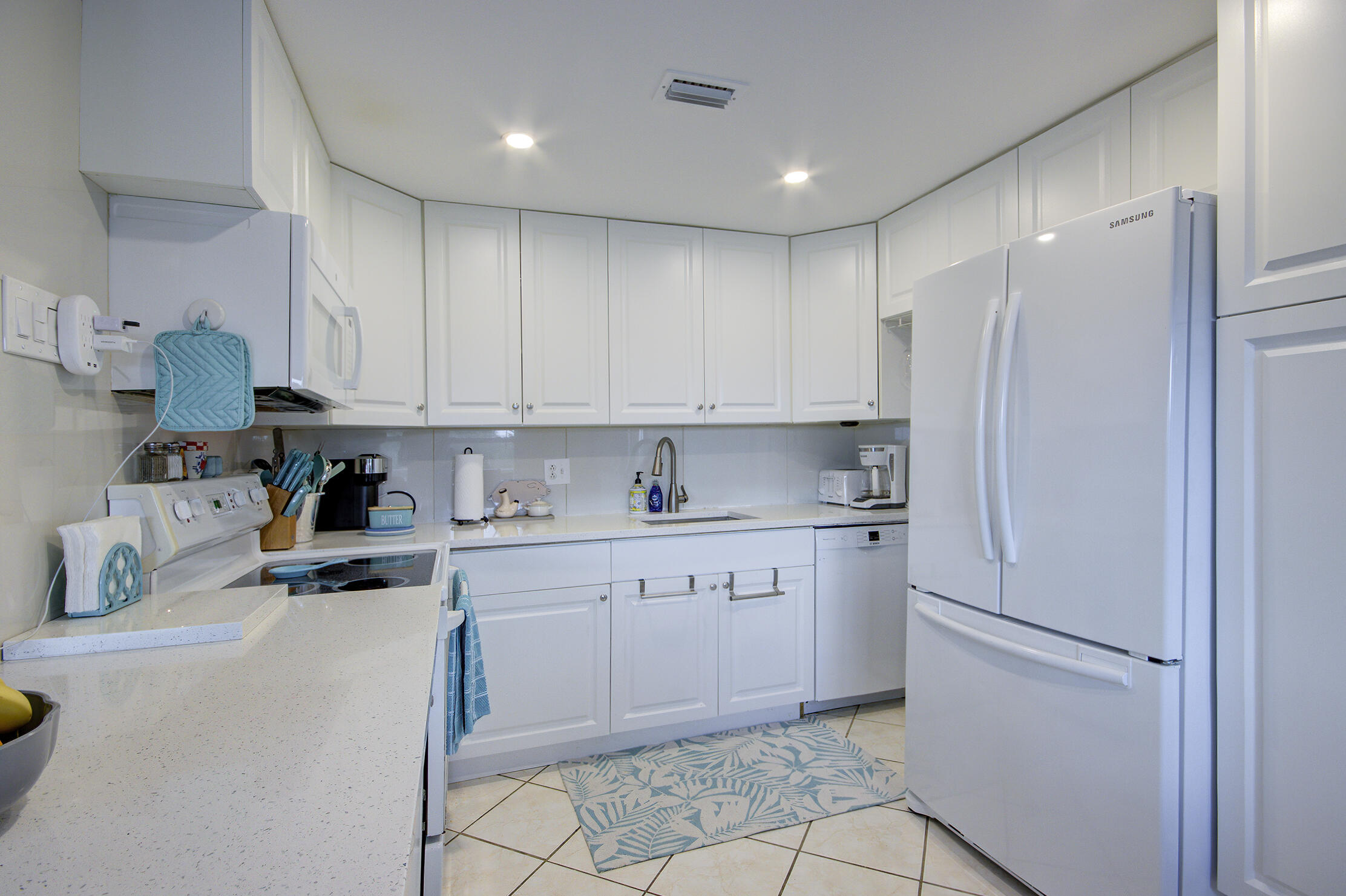 363 Wellington J West Palm Beach, FL 33417 - Photo 7 of 17 a kitchen with stainless steel appliances granite countertop a refrigerator sink and white cabinets