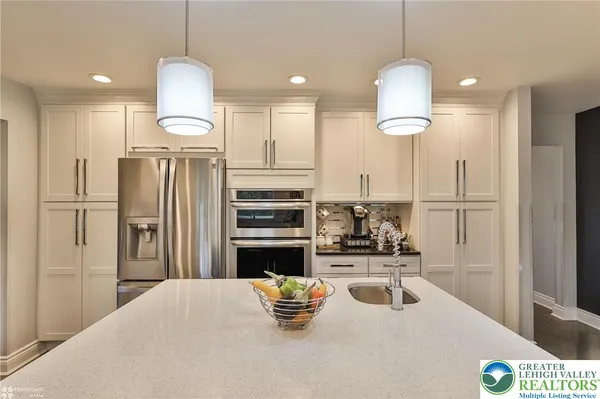 a kitchen with stainless steel appliances kitchen island granite countertop a refrigerator and a stove