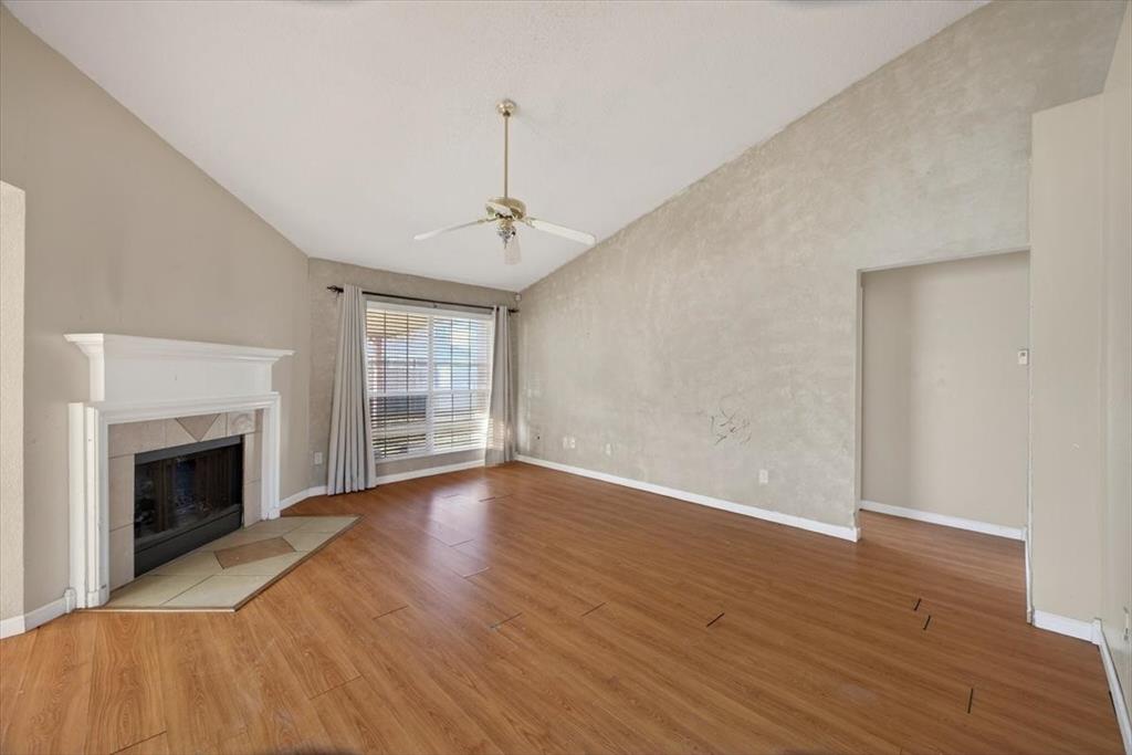 920 Danforth Place Arlington, TX 76017 - Photo 6 of 28 a view of an empty room with wooden floor fireplace and a window