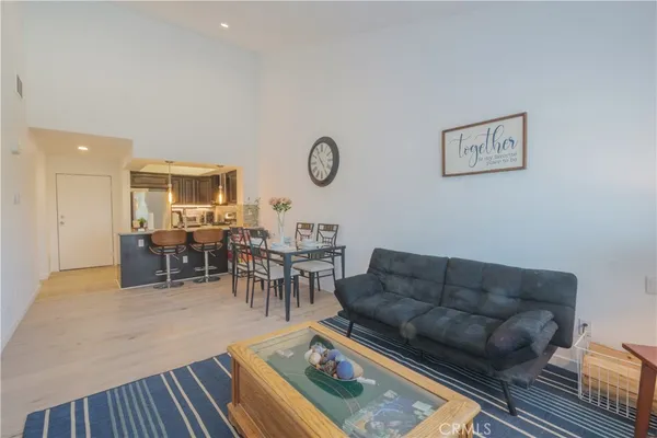 a living room with furniture a clock on wall and a table