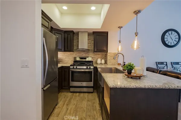 a kitchen with granite countertop a sink stove and refrigerator