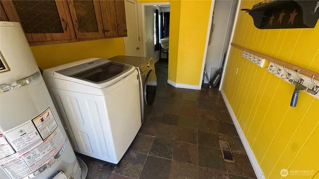 a utility room with wooden floor washer and dryer