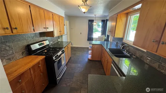 a kitchen with blue cabinets a sink a stove and a window