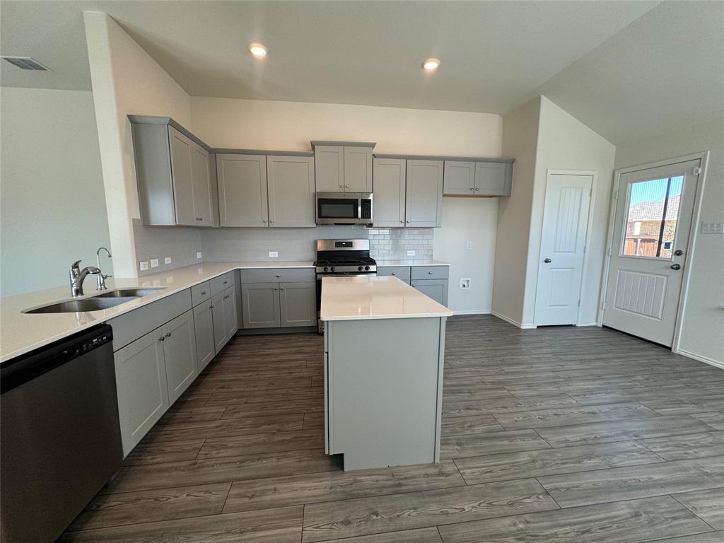 4700 Essonite Road Little Elm, TX 76227 - Photo 11 of 37 a kitchen with a sink a stove and cabinets