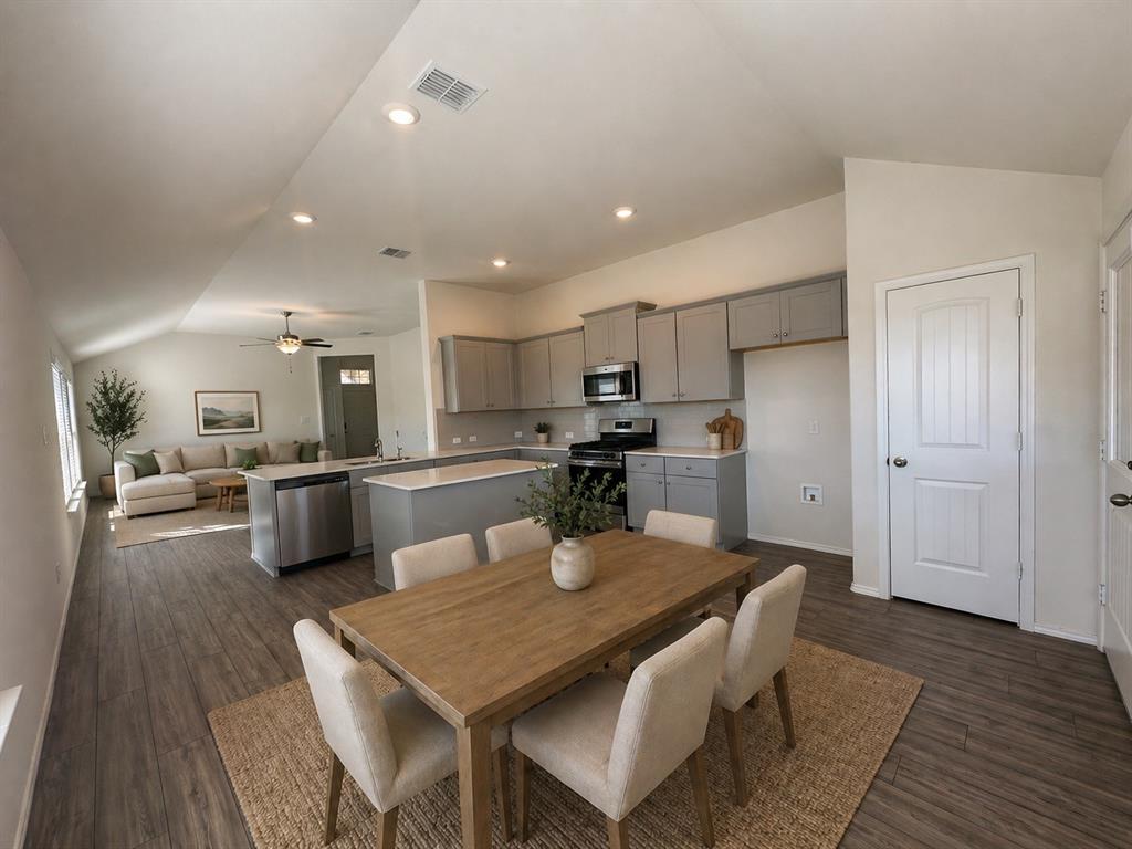 4700 Essonite Road Little Elm, TX 76227 - Photo 12 of 37 a kitchen with stainless steel appliances a dining table chairs refrigerator and microwave