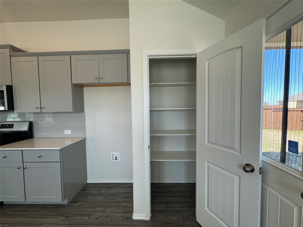 4700 Essonite Road Little Elm, TX 76227 - Photo 15 of 37 a kitchen with a refrigerator and white cabinets