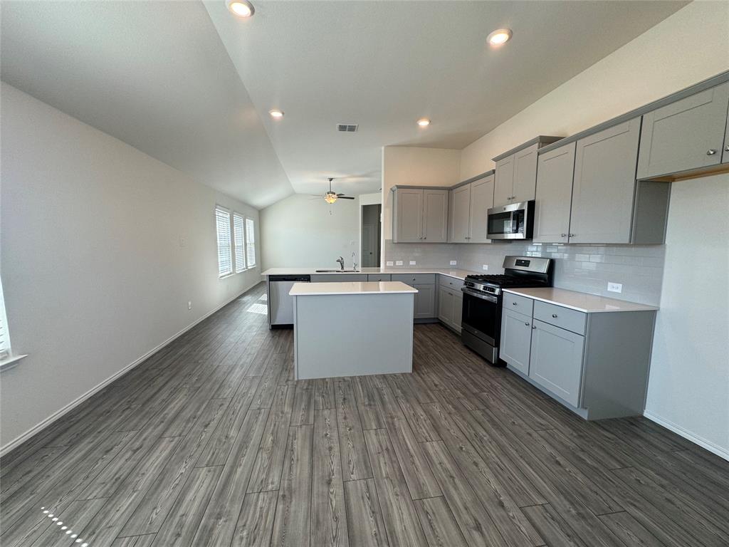4700 Essonite Road Little Elm, TX 76227 - Photo 10 of 37 a kitchen with wooden floors and white stainless steel appliances