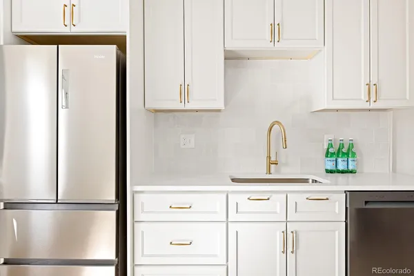 a kitchen with stainless steel appliances white cabinets and a refrigerator