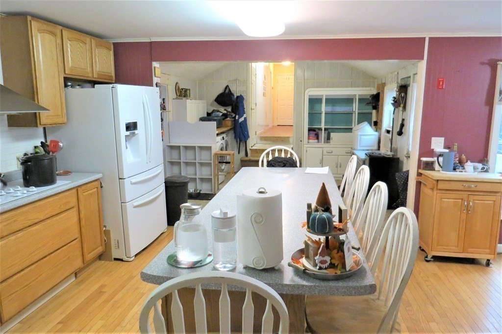 114 North Main Street Salem, NH 03079 - Photo 7 of 26 a kitchen with stainless steel appliances kitchen island granite countertop a refrigerator a stove and a wooden floor