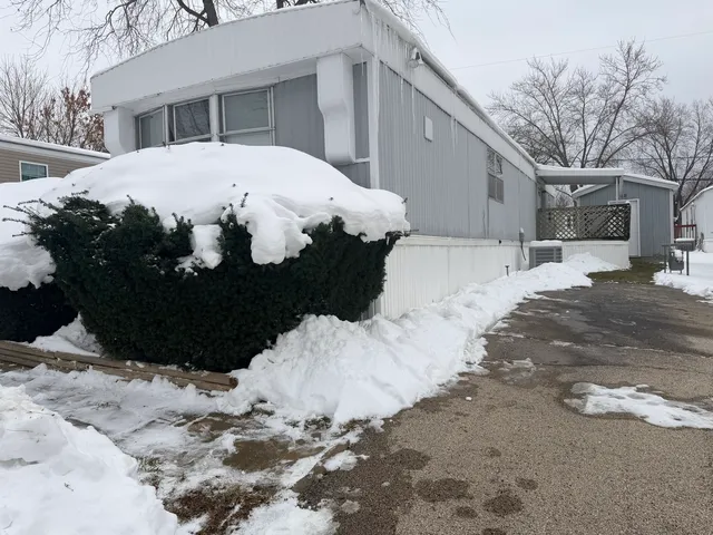 a view of a white house with a yard covered in snow