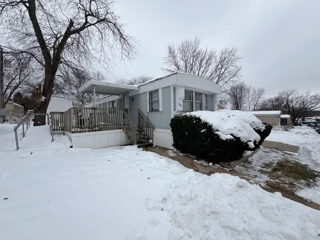 a front view of a house with a yard covered in snow