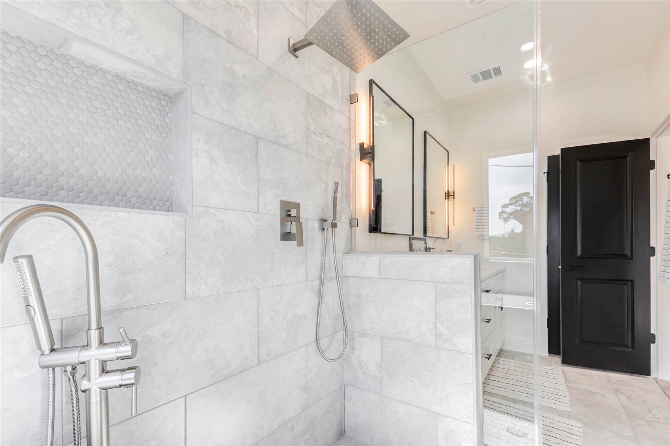 7115 England Street, Unit C Houston, TX 77021 - Photo 9 of 19 The walk-in shower features a rainfall showerhead, integrated wall niche, and sleek glass partitioning.