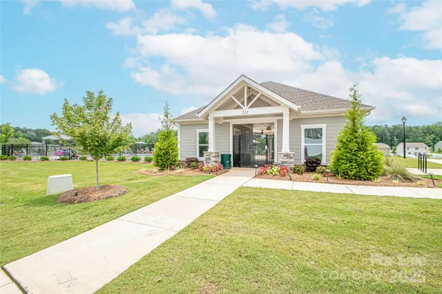 a front view of a house with a yard and trees