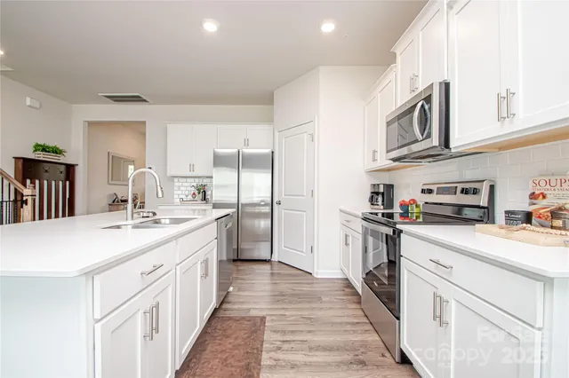 a kitchen with stainless steel appliances a sink stove top oven and refrigerator