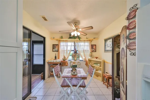 a view of a dining room with furniture and a chandelier fan