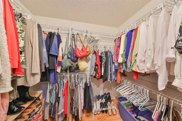 a view of walk in closet with clothes