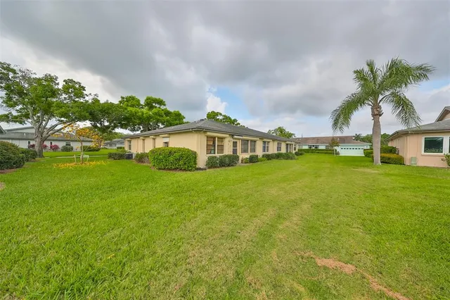 a view of a house with a yard and potted plants