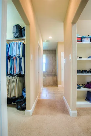 a view of walk in closet with clothes and shoes