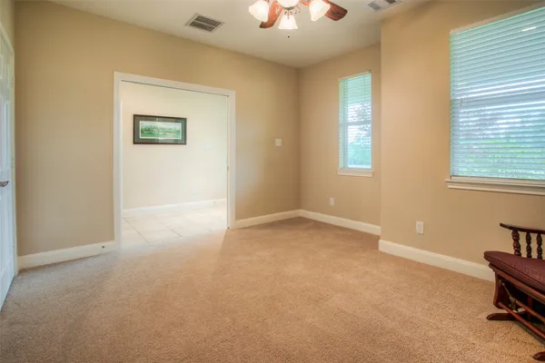 en empty room with windows and ceiling fan