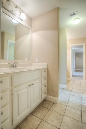 a spacious bathroom with a mirror sink and vanity