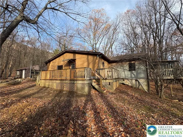 a front view of a house with large trees