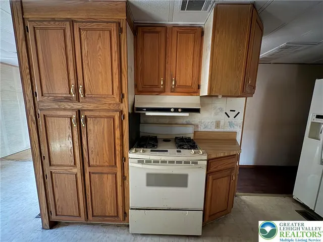 a white refrigerator freezer and a stove sitting inside of a kitchen