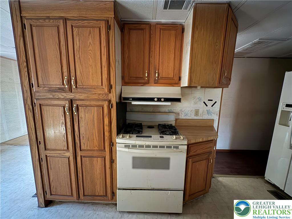 1433 Deer Path Drive Walnutport, PA 18088 - Photo 21 of 39 a kitchen with wooden cabinets and white appliances