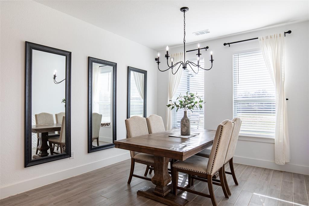 111 Bluegrass Trail Springtown, TX 76082 - Photo 19 of 37 Dining room with designer chandelier and wall of windows overlooking the scenic backyard.