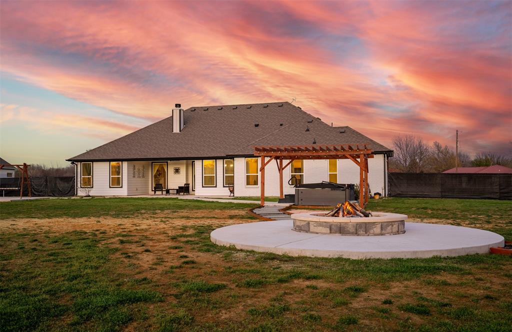 111 Bluegrass Trail Springtown, TX 76082 - Photo 32 of 37 Backyard with sidewalk leading to covered pergola, and firepit area with concrete decking.