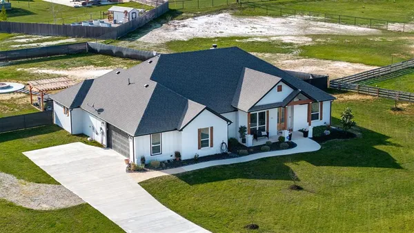 a aerial view of a house with swimming pool and a yard