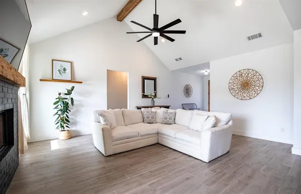 a living room with furniture and a wooden floor