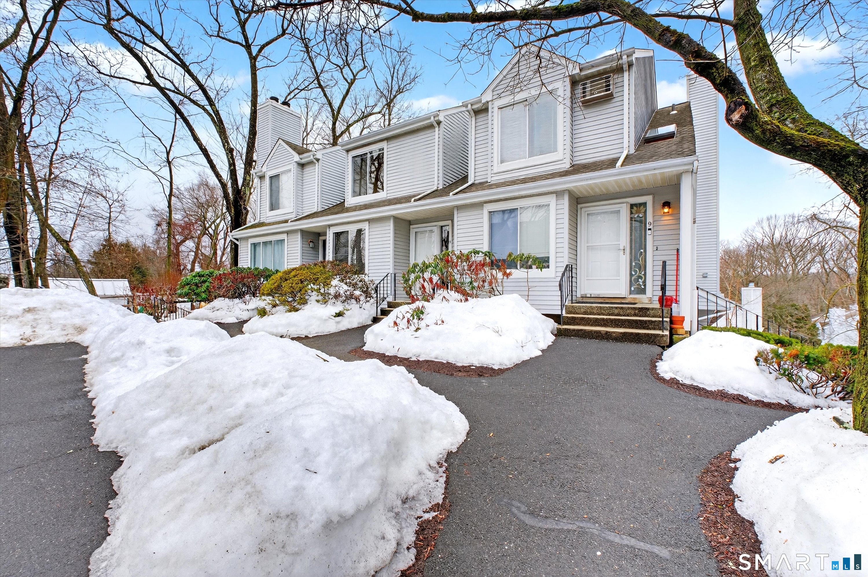 a view of a white house with a yard covered in snow