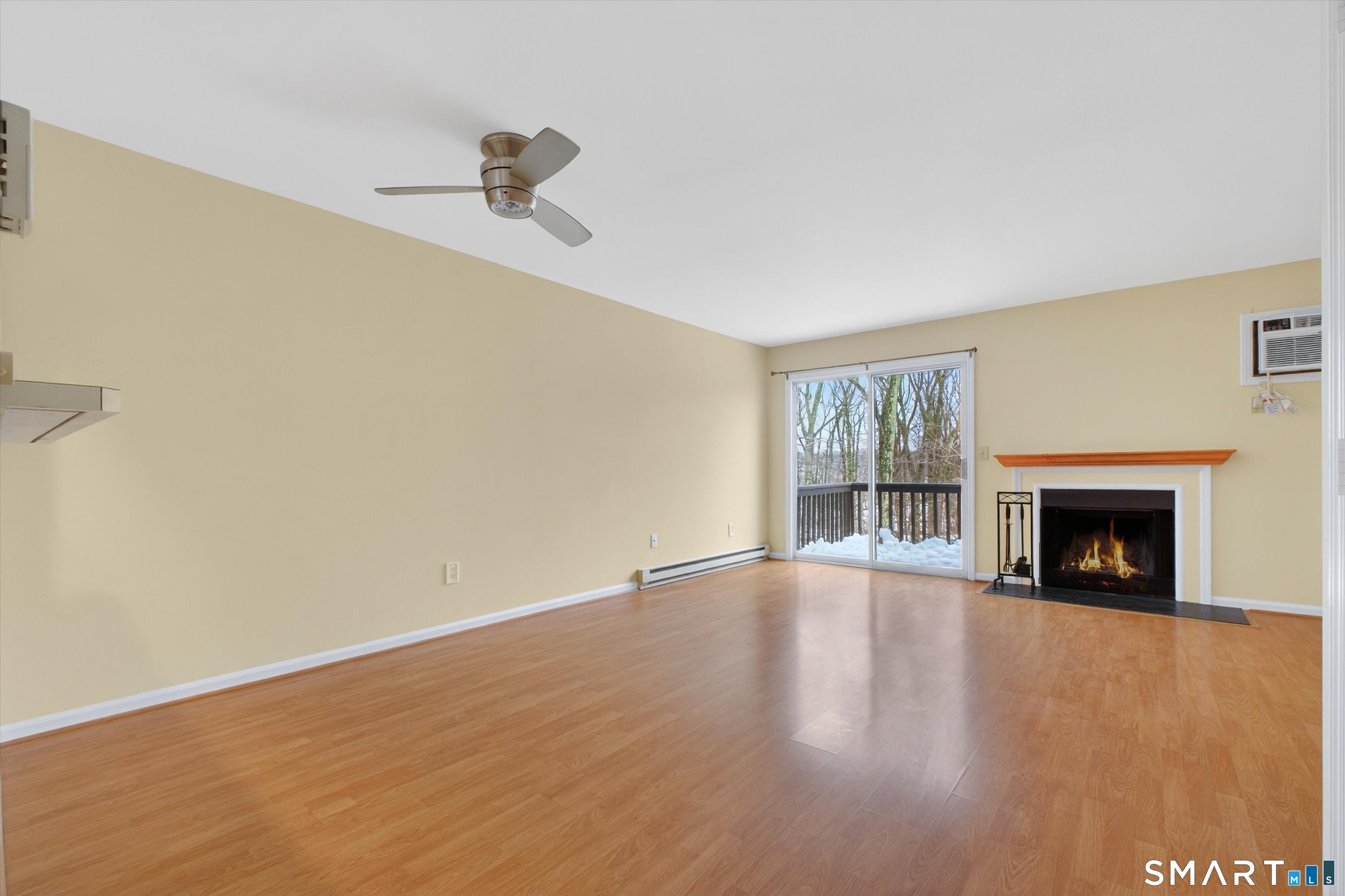20 East Pembroke Road, Unit 8 Danbury, CT 06811 - Photo 9 of 23 a view of an empty room with wooden floor fireplace and a window